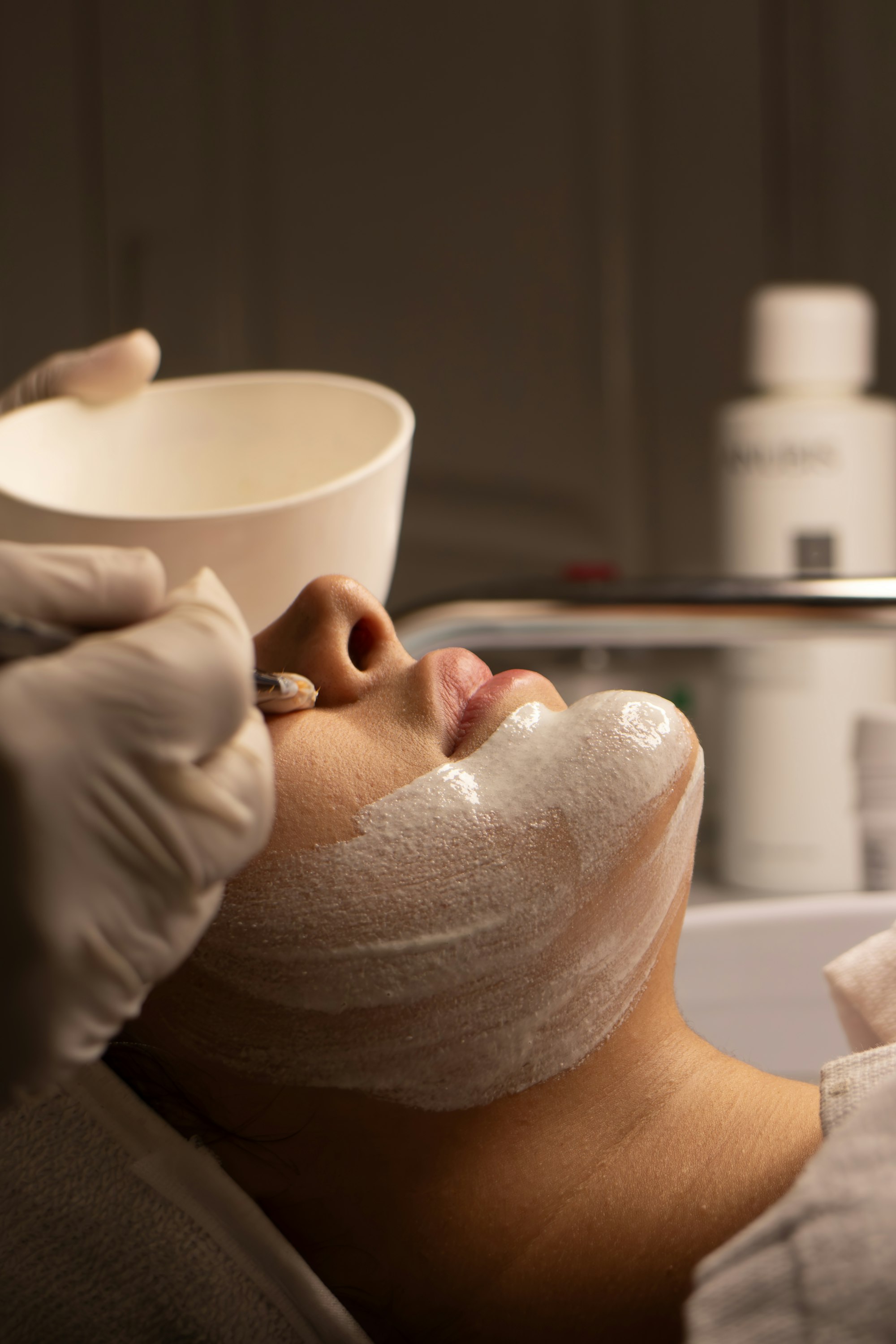 Client relaxing with a soothing face mask during a facial